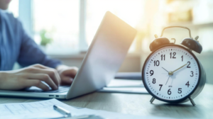 Employee using a PTO accrual calculator on a laptop with a clock and calendar in the background.