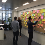 Team collaborating on Agile sprint planning with digital Kanban board.